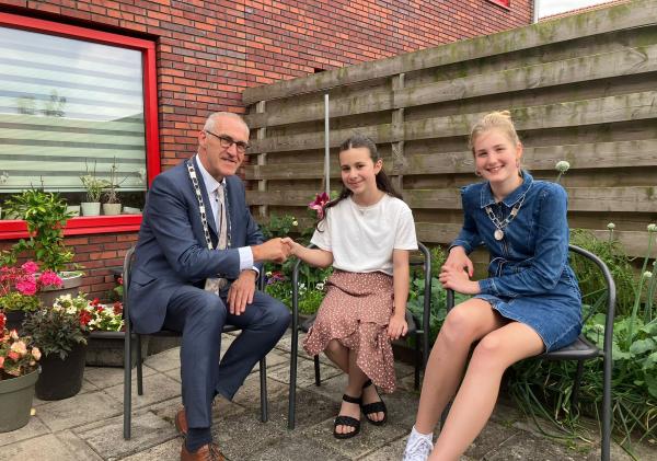 Belinay Babuscu is de nieuwe kinderburgemeester van de gemeente Midden-Groningen. Ze wordt gefeliciteerd door burgemeester Adriaan Hoogendoorn en huidige kinderburgemeester Lieke Kruijer.