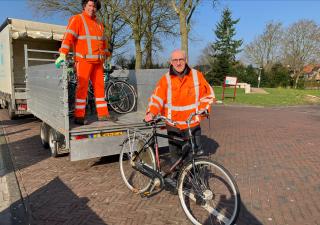 Burgemeester Adriaan Hoogendoorn ruimt een fiets op het station op