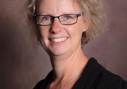 Vrouw met blond haar en bril.