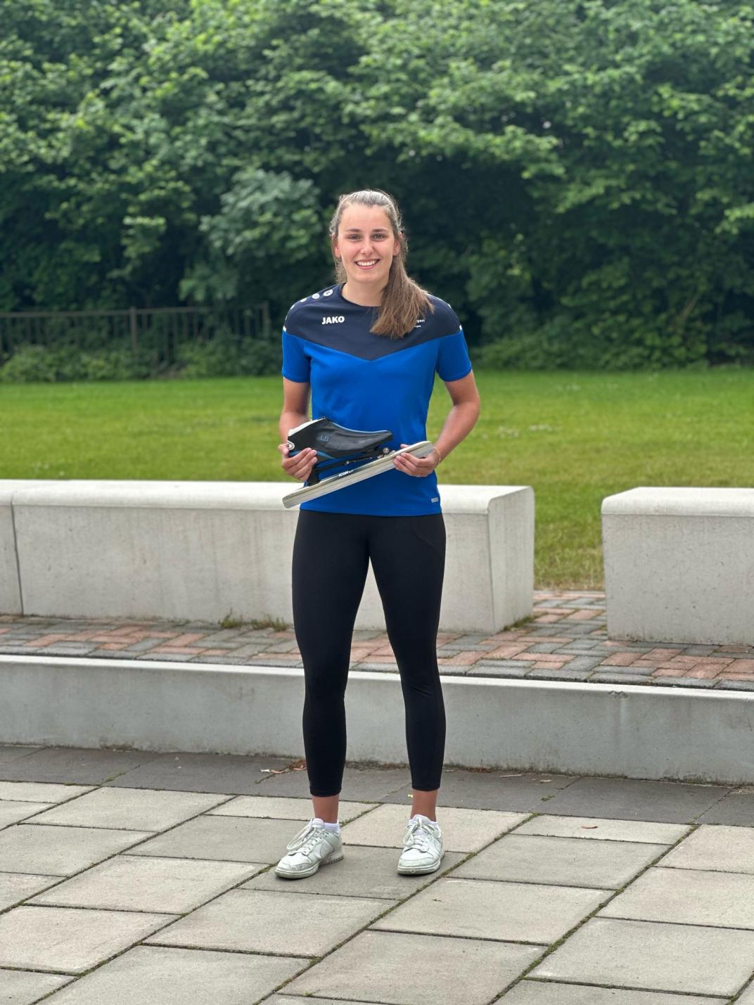 Lachende foto van beweegcoach Leonie met een schaats in haar handen.
