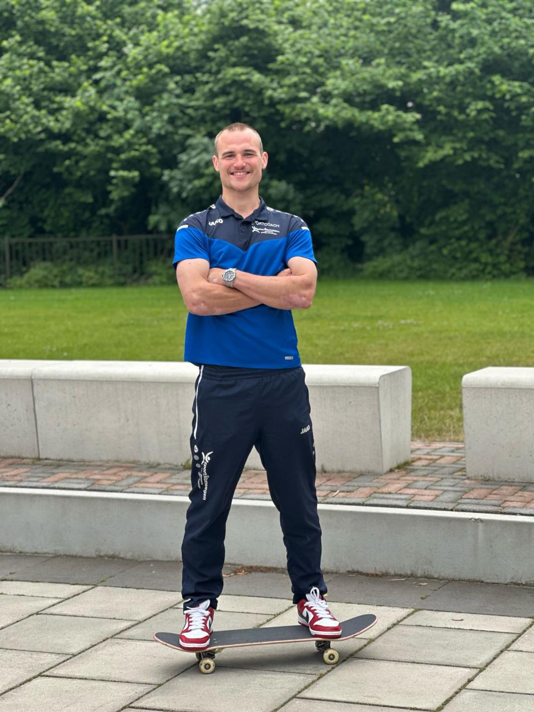 Lachende foto van sportcoach Robbin op een skateboard.