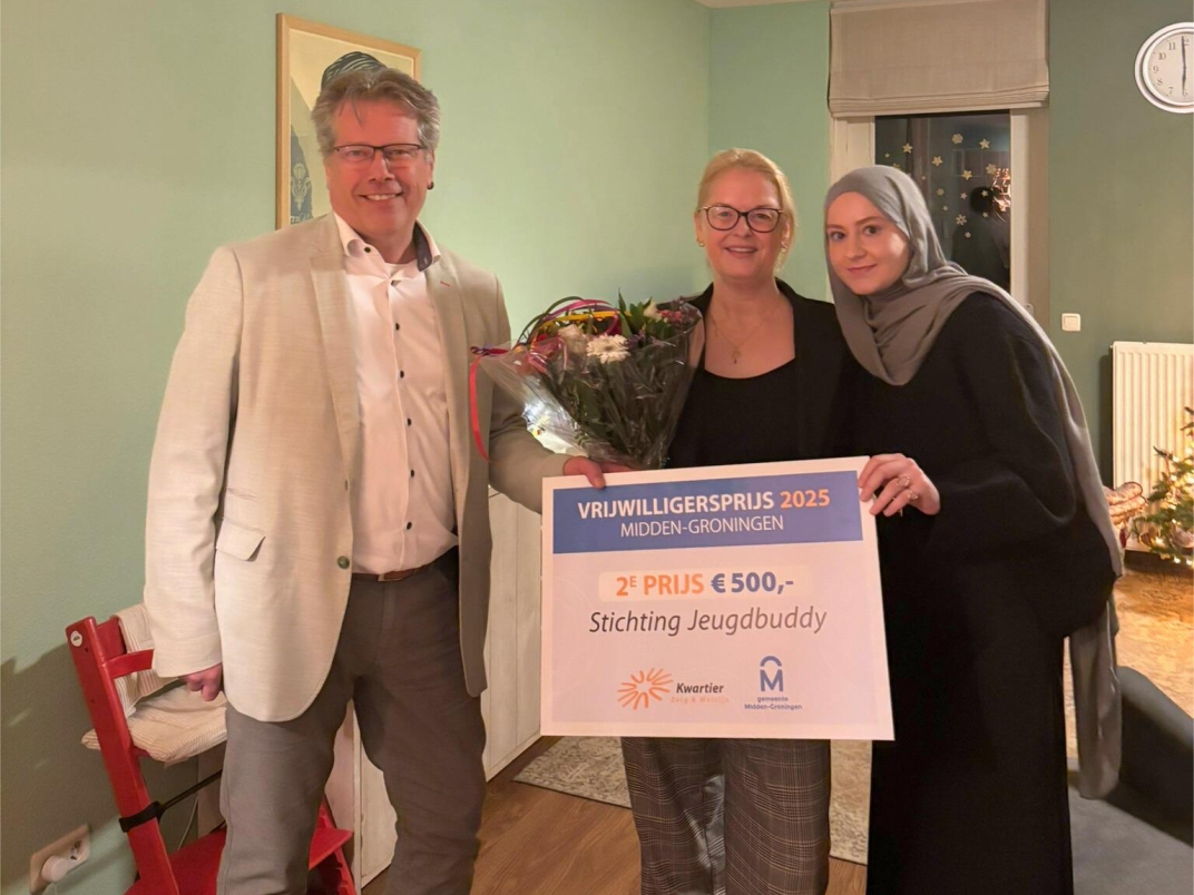 Wethouder Evert Offereins rijkt de Vrijwilligersprijs uit aan vrijwilligers van Stichting Jeugdbuddy