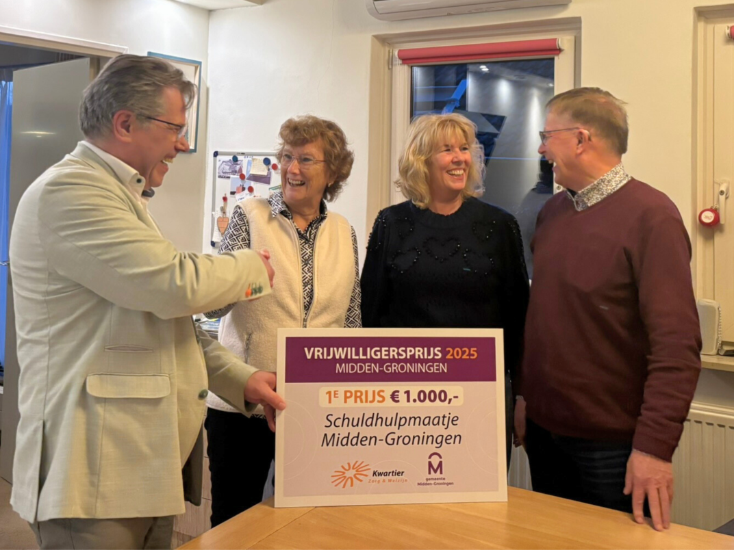 Wethouder Evert Offereins rijkt de vrijwilligersprijs uit aan Stichting SchuldhulpMaatje Midden-Groningen