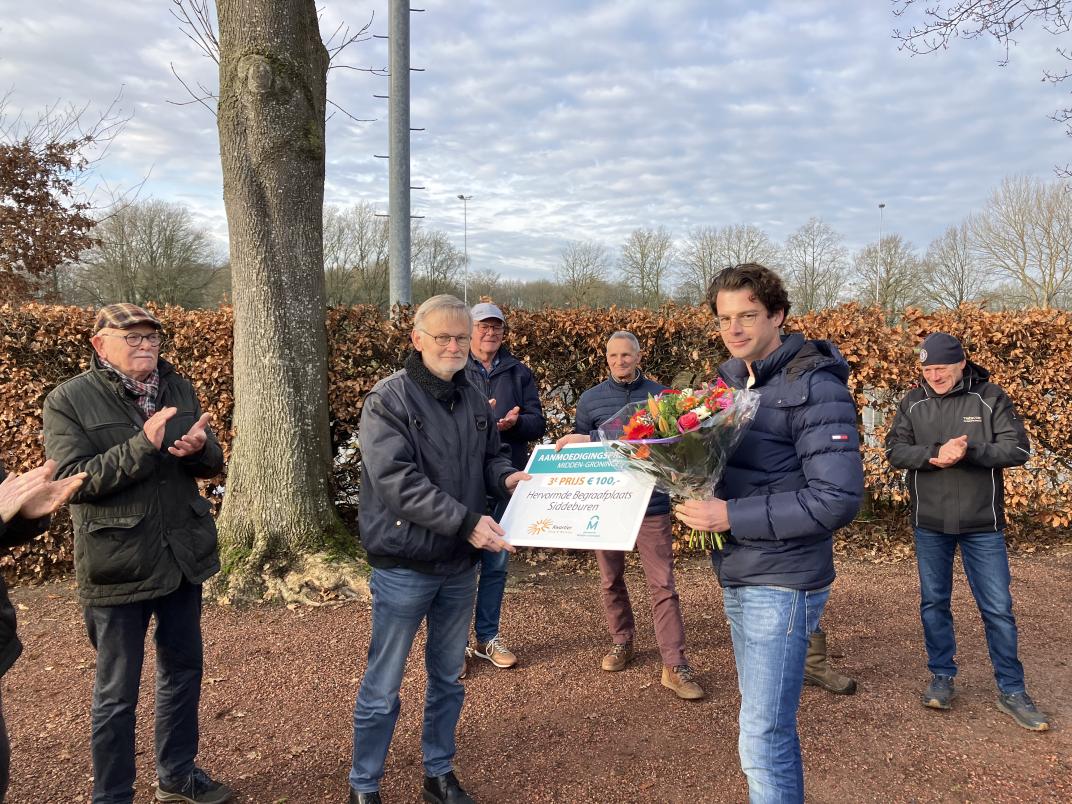 Yannick Lutterop reikt de Vrijwilligersprijs uit aan de vrijwilligers van de Hervormde Begraafplaats Siddeburen.