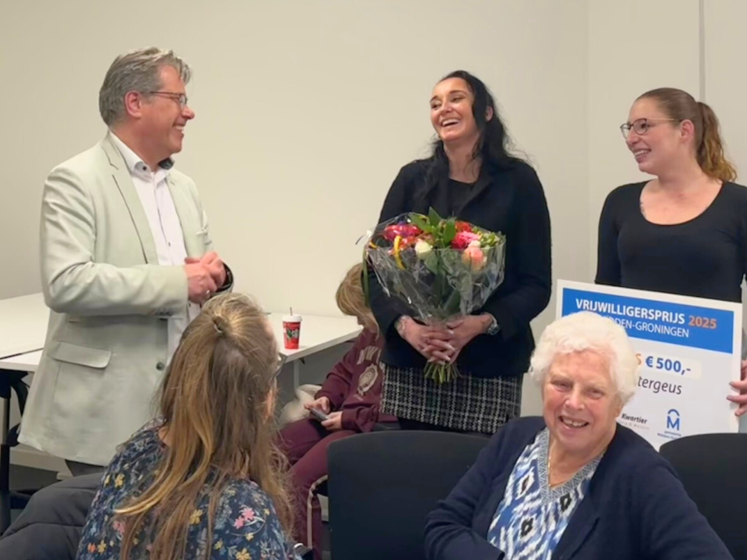 Wethouder Evert Offereins rijkt de vrijwilligersprijs uit aan de vrijwilligers van Zwemvereniging de Watergeus