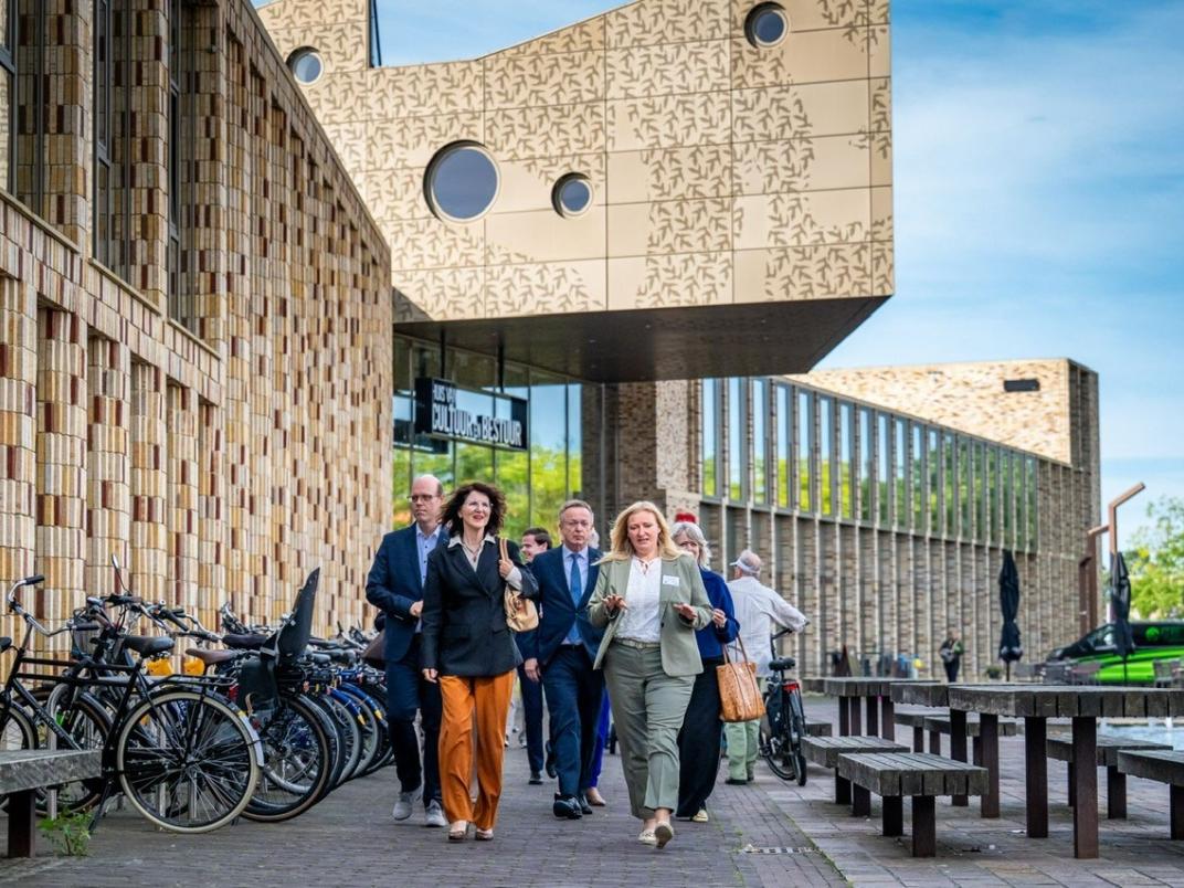 Staatssecretaris Annet Bertram loopt voor het Huis van Cultuur en Bestuur. 